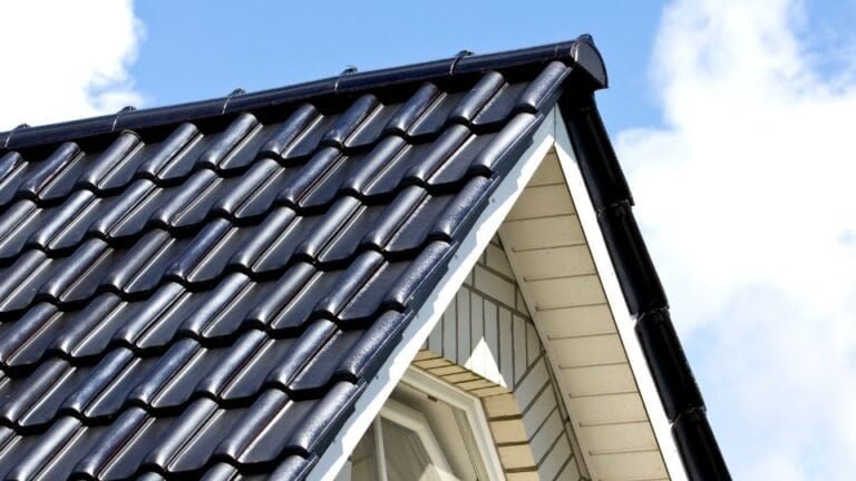 A roof covered with sleek black tiles arranged in neat rows, giving the house a modern and polished look. The dark color enhances durability and weather resistance while providing a stylish contrast against the sky or surrounding architecture.