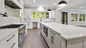 A clean kitchen with white cabinets and counter tops.