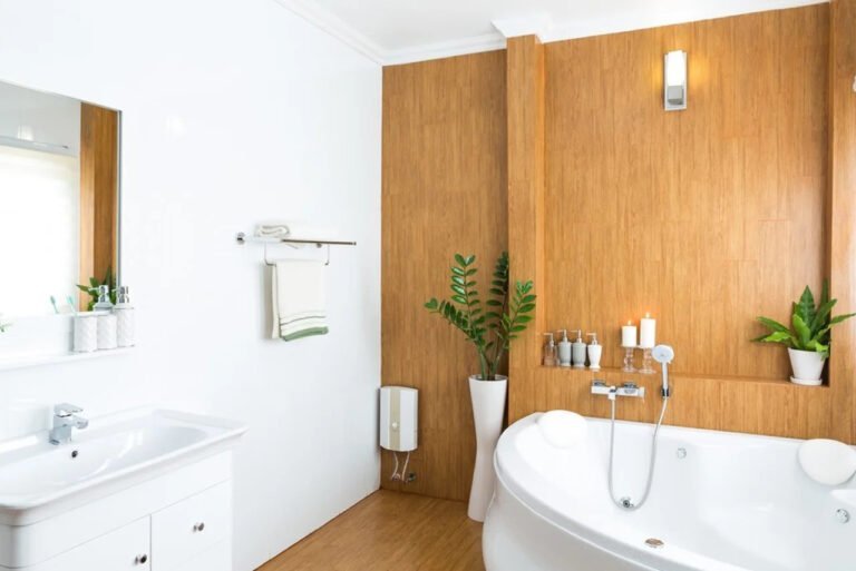 A bathroom featuring a white bathtub set against wooden paneled walls. The space may include a sink and toilet, with natural or artificial lighting highlighting the warm tones of the wood and the clean, bright surface of the tub. The combination creates a cozy and rustic yet modern aesthetic.