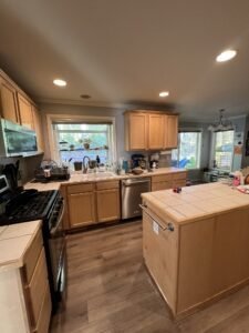 A modern kitchen featuring a spacious central island and stainless steel appliances, including a refrigerator, oven, and dishwasher. The island provides ample workspace and seating, while the bright, well-organized layout emphasizes both style and functionality.