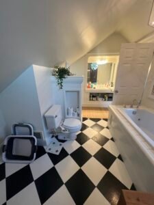 Modern bathroom with black and white checkered floor and bathtub.