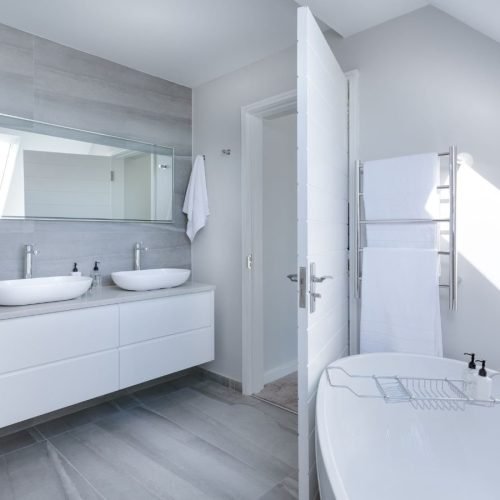 Modern bathroom with white fixtures and a large mirror.