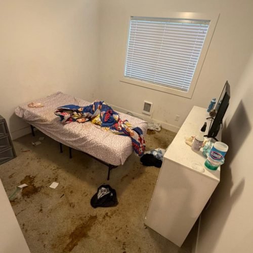 A messy room with a stained carpet, unmade bed, and cluttered dresser—great for flooring contractor work.