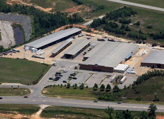 “Workers performing roofing work on a factory or industrial building. The roof is made of metal sheets or industrial-grade materials, with scaffolding, tools, and safety equipment visible. The team is installing or repairing the roofing structure for durability and protection.”
